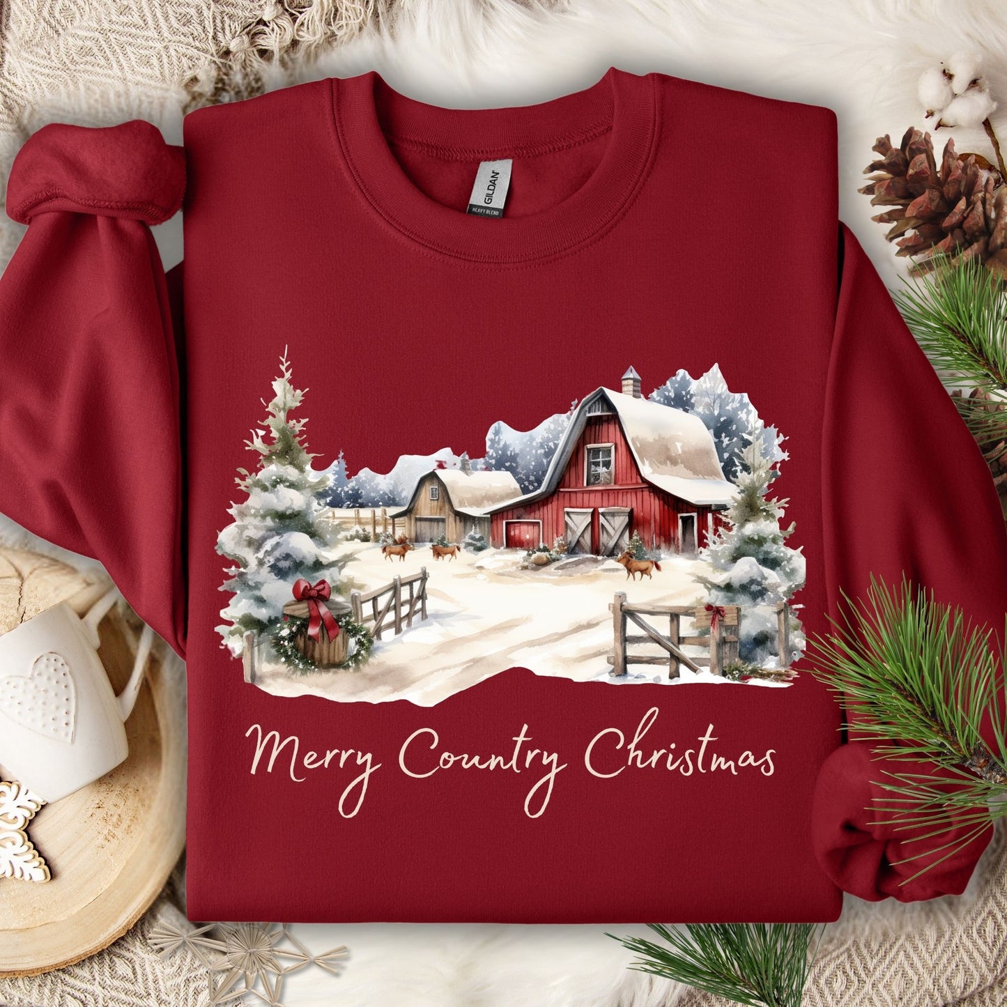 Cardinal Red Gildan sweatshirt with a watercolor snow-covered barn, trees, and "Merry Country Christmas" text.