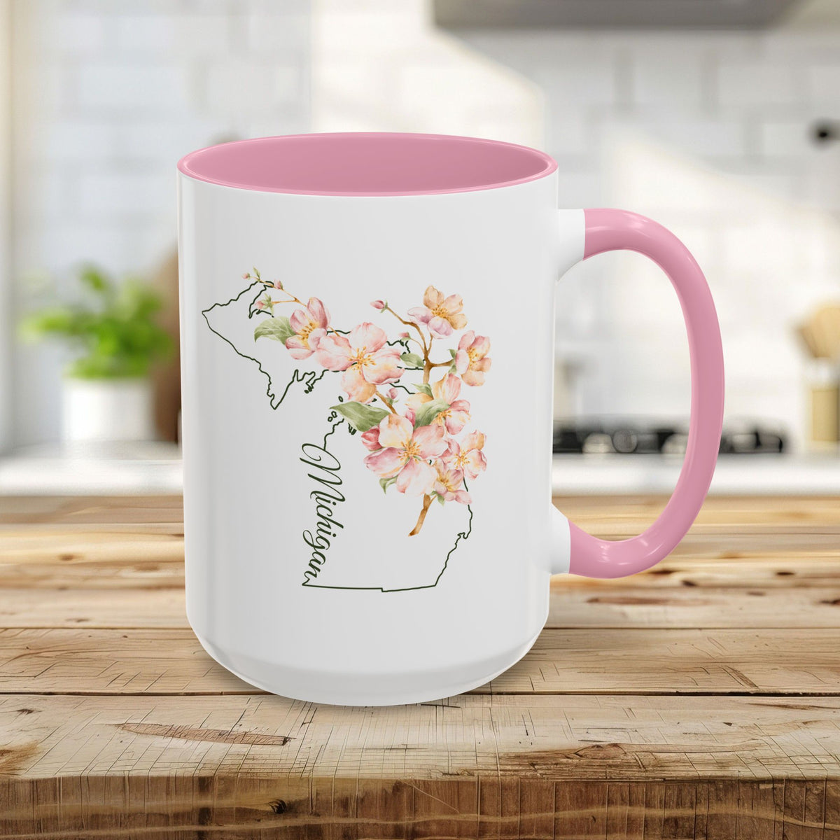 15oz white ceramic mug with pink handle and interior, featuring a Michigan map outline with apple blossoms.