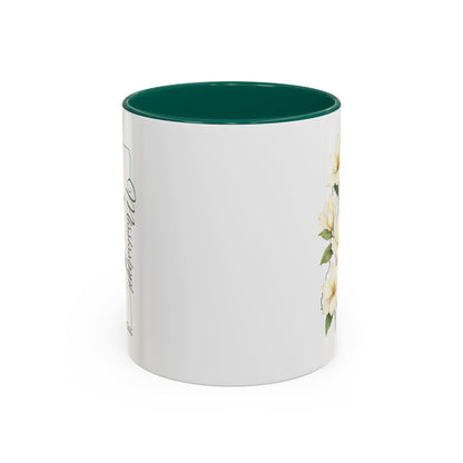 White ceramic mug with green interior, featuring delicate magnolia blooms and a Mississippi state outline.