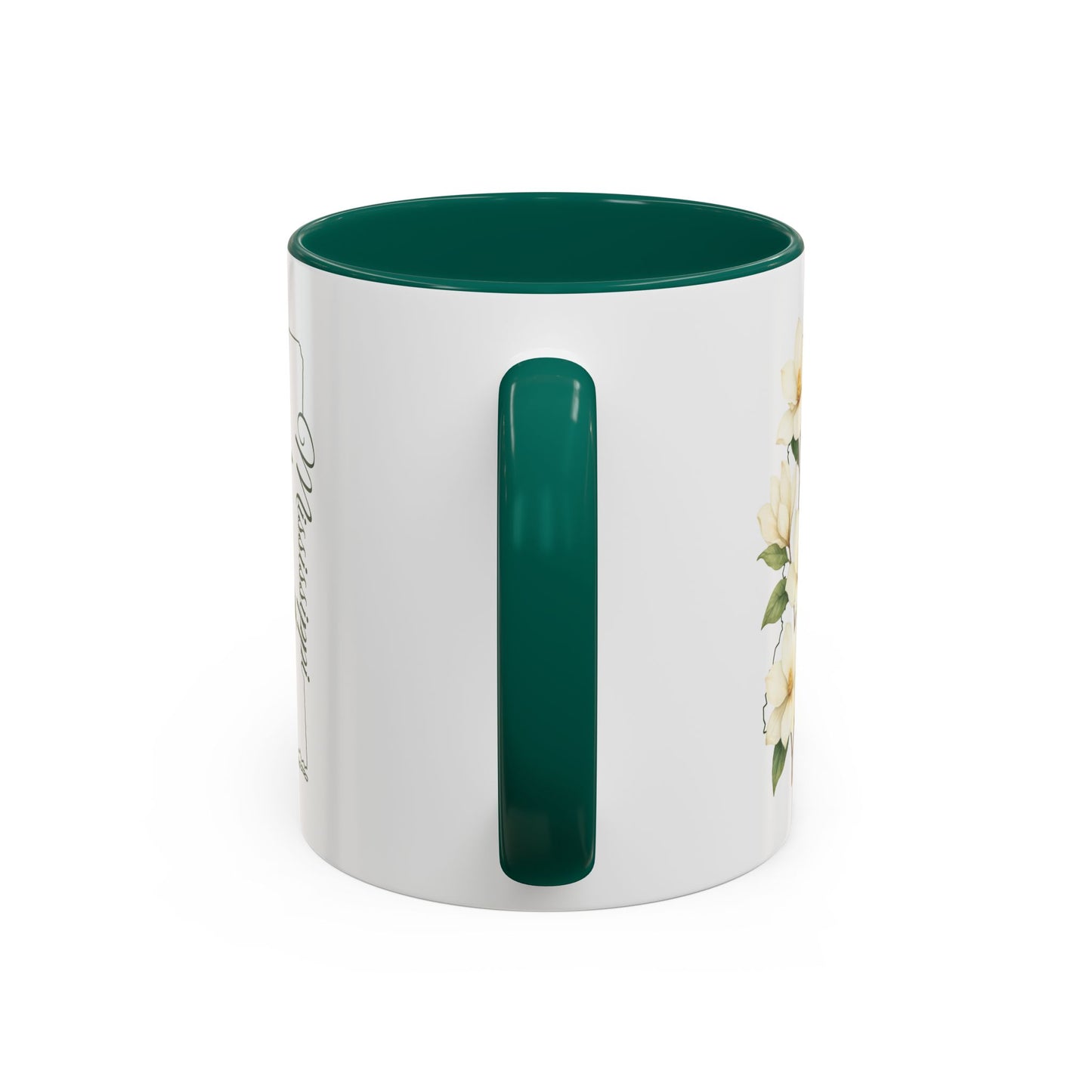 White ceramic mug with green handle and interior, featuring delicate magnolia blooms and "Mississippi" script.