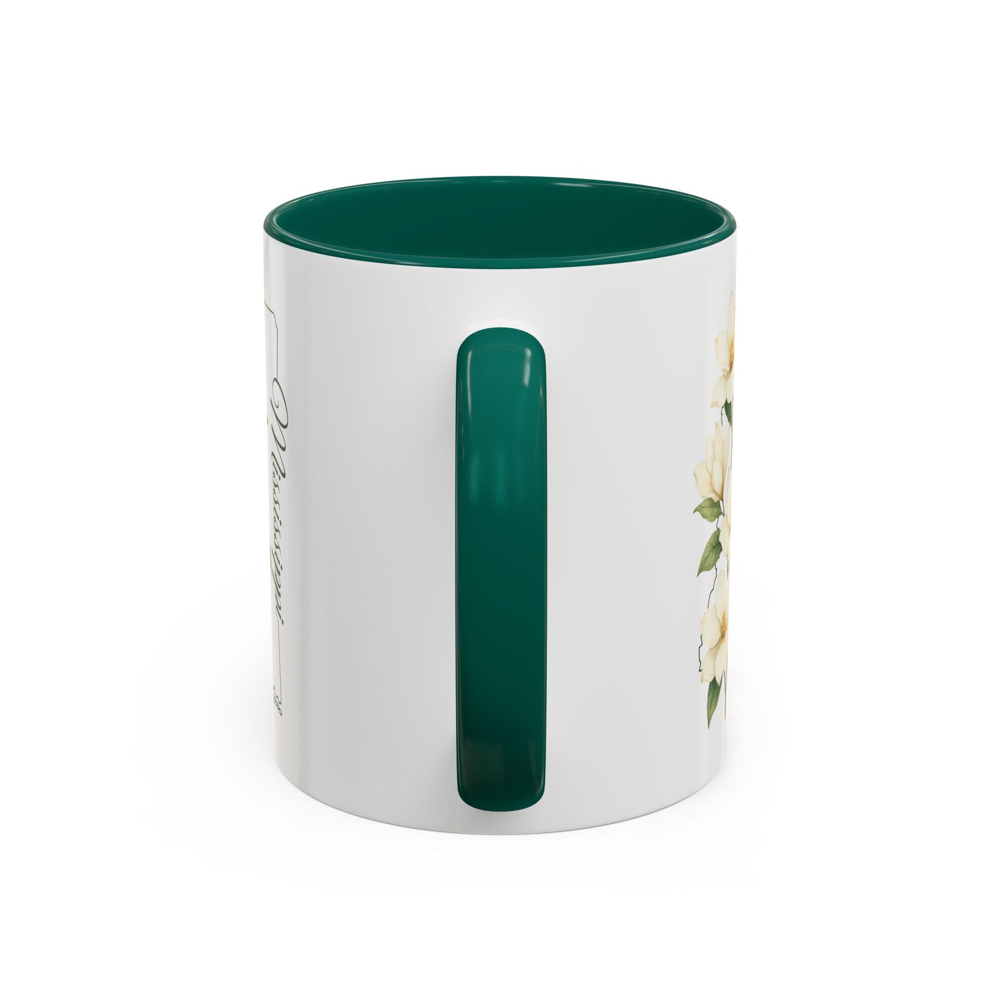 White ceramic mug with green handle and interior, featuring delicate magnolia blooms and "Mississippi" script.