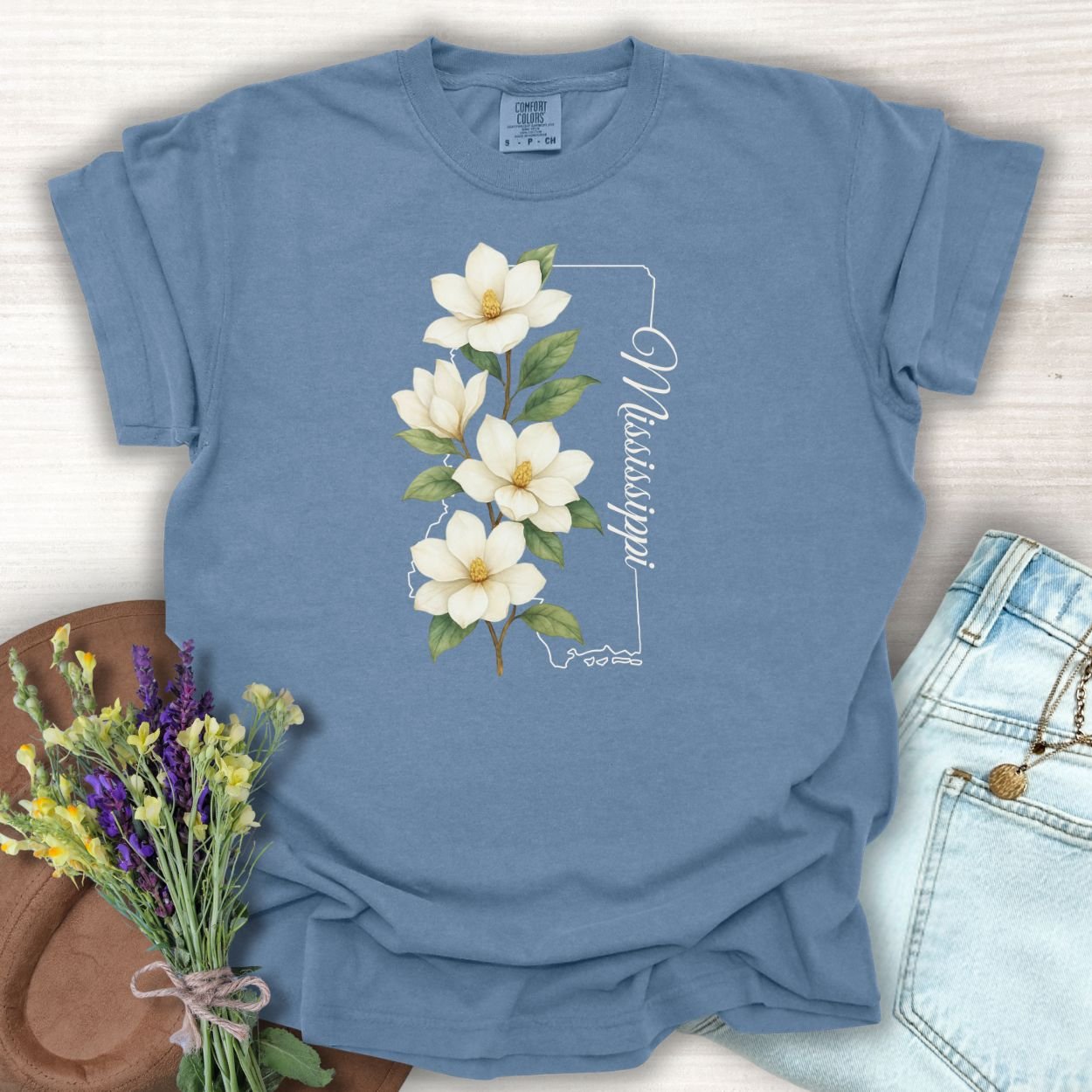 Blue Jean S relaxed-fit, garment-dyed cotton t-shirt with a magnolia illustration and Mississippi state outline.