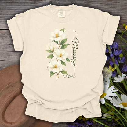 Ivory S, relaxed-fit, garment-dyed cotton t-shirt with a magnolia illustration and Mississippi state outline.