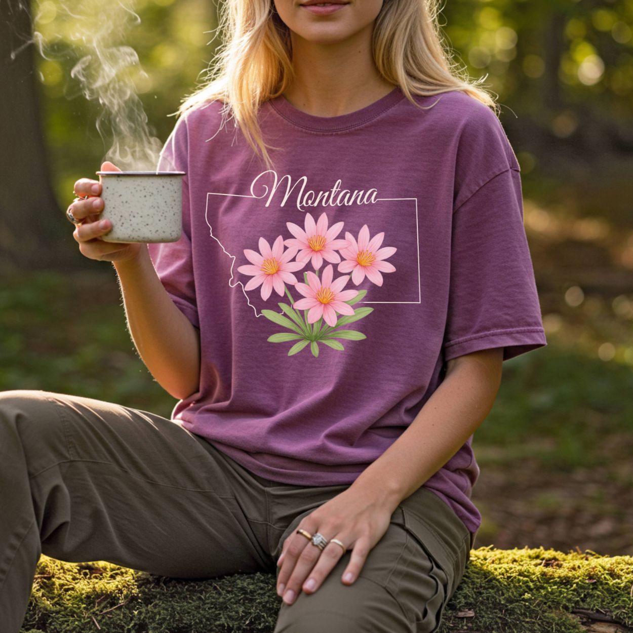 Garment-dyed plum t-shirt with a Montana outline and hand-drawn pink bitterroot wildflowers.