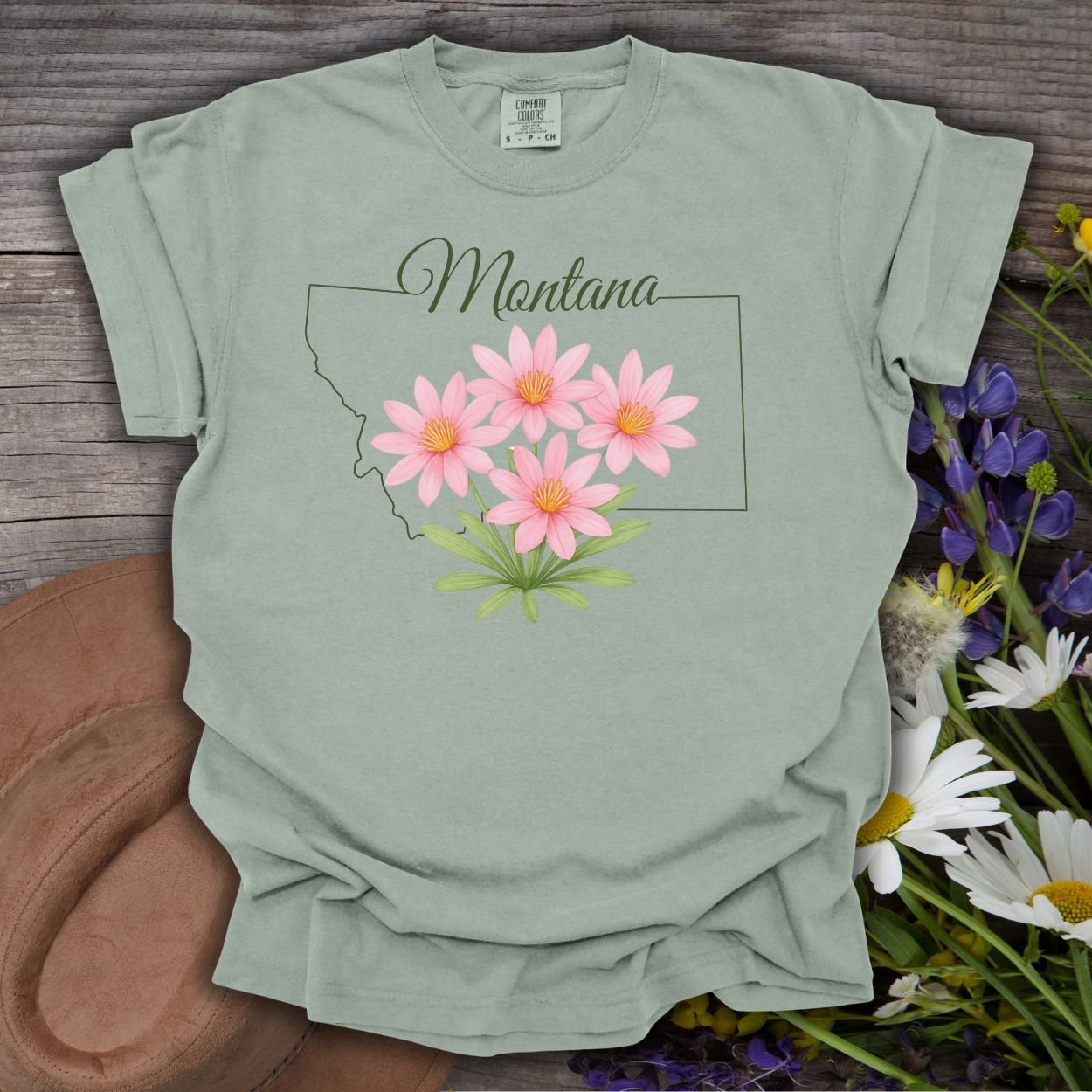 Bay green relaxed-fit cotton t-shirt with a Montana outline and pink Bitterroot wildflowers.