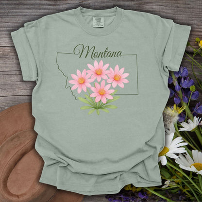 Bay green relaxed-fit cotton t-shirt with a Montana outline and pink Bitterroot wildflowers.