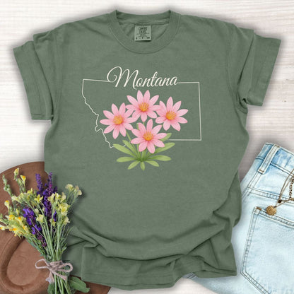Moss green Montana State Flower T-shirt with pink Bitterroot wildflowers, 100% cotton, relaxed fit.