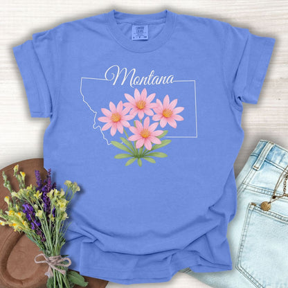 Periwinkle S t-shirt with a Montana outline and pink Bitterroot wildflowers.
