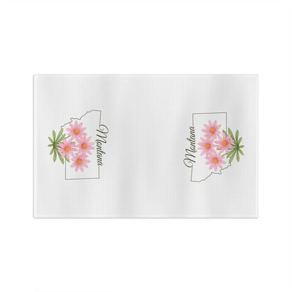 White microfiber tea towel with Montana state outline, pink bitterroot flowers, and "Montana" script.
