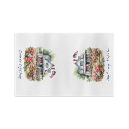 White microfiber tea towel with watercolor farmhouse, blooming garden, flag, and patriotic text.