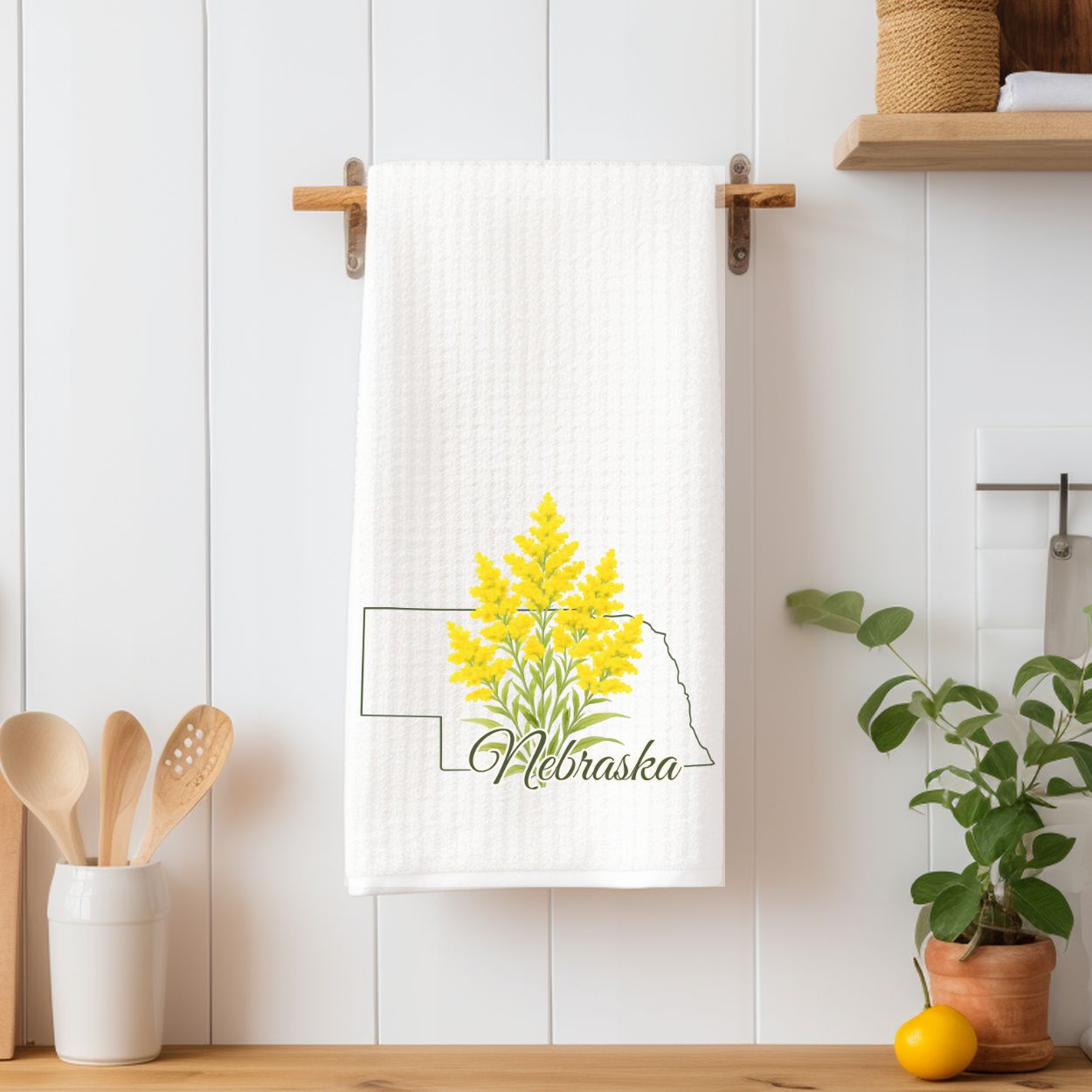 White 16x25 microfiber tea towel with a goldenrod design inside a Nebraska state outline.