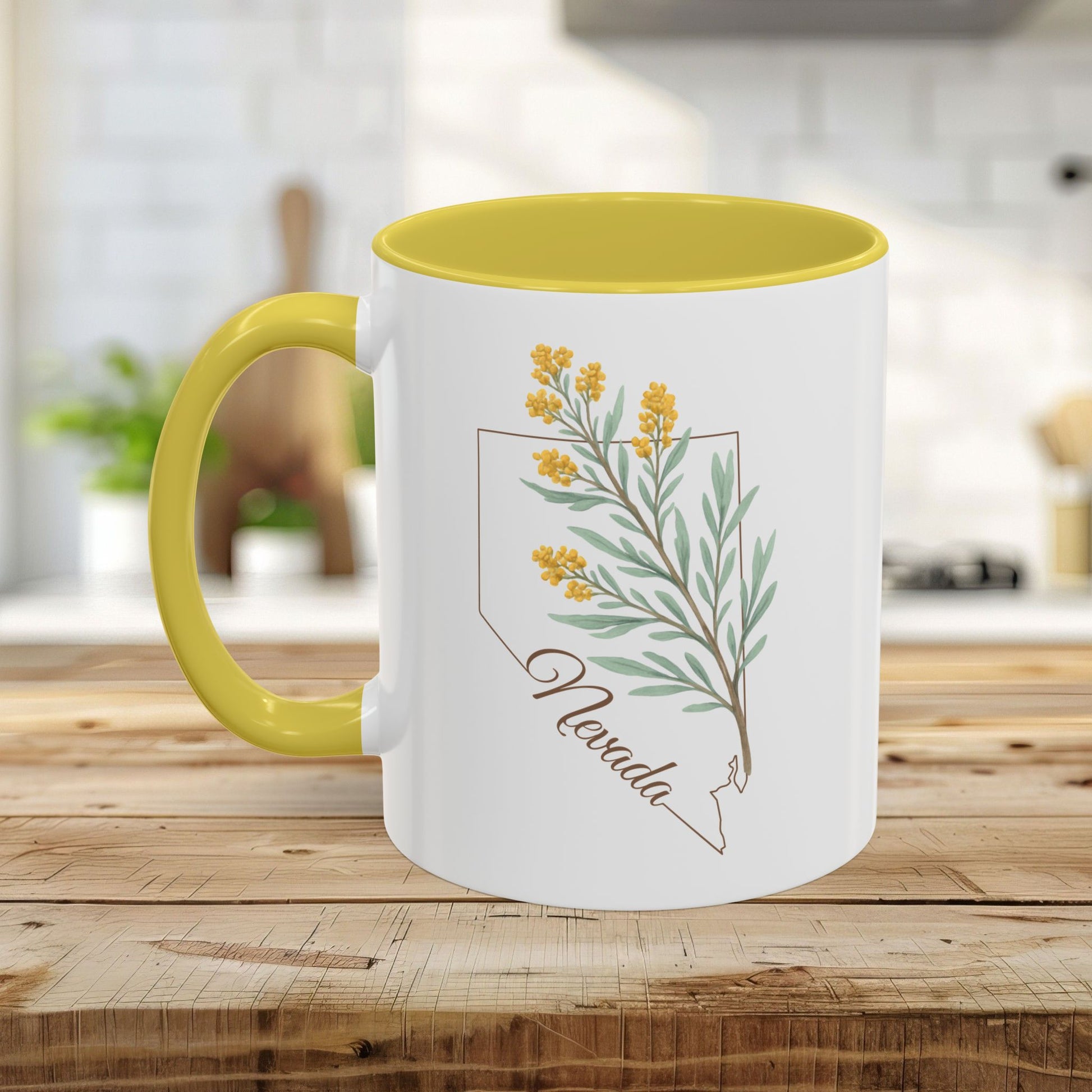 White ceramic mug with yellow interior and handle, featuring a watercolor Nevada state outline and sagebrush design.