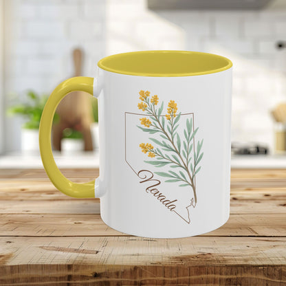White ceramic mug with yellow interior and handle, featuring a watercolor Nevada state outline and sagebrush design.