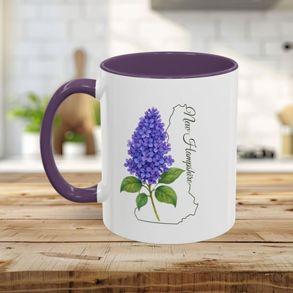 White ceramic mug with purple lilac illustration, New Hampshire outline, and purple handle/interior.