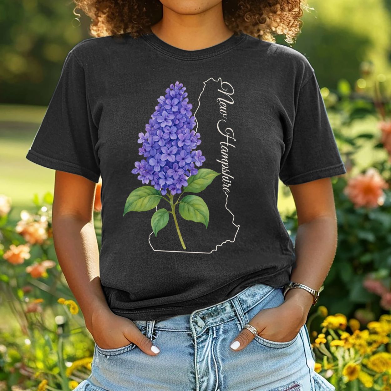 Garment-dyed black cotton t-shirt with a watercolor lilac sprig and "New Hampshire" state outline.