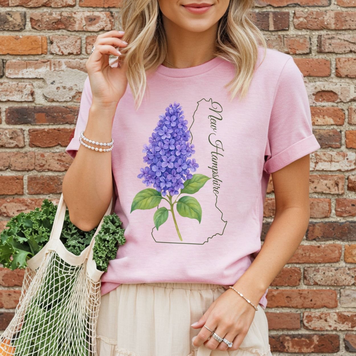 Pink t-shirt with a watercolor lilac sprig and New Hampshire state outline.