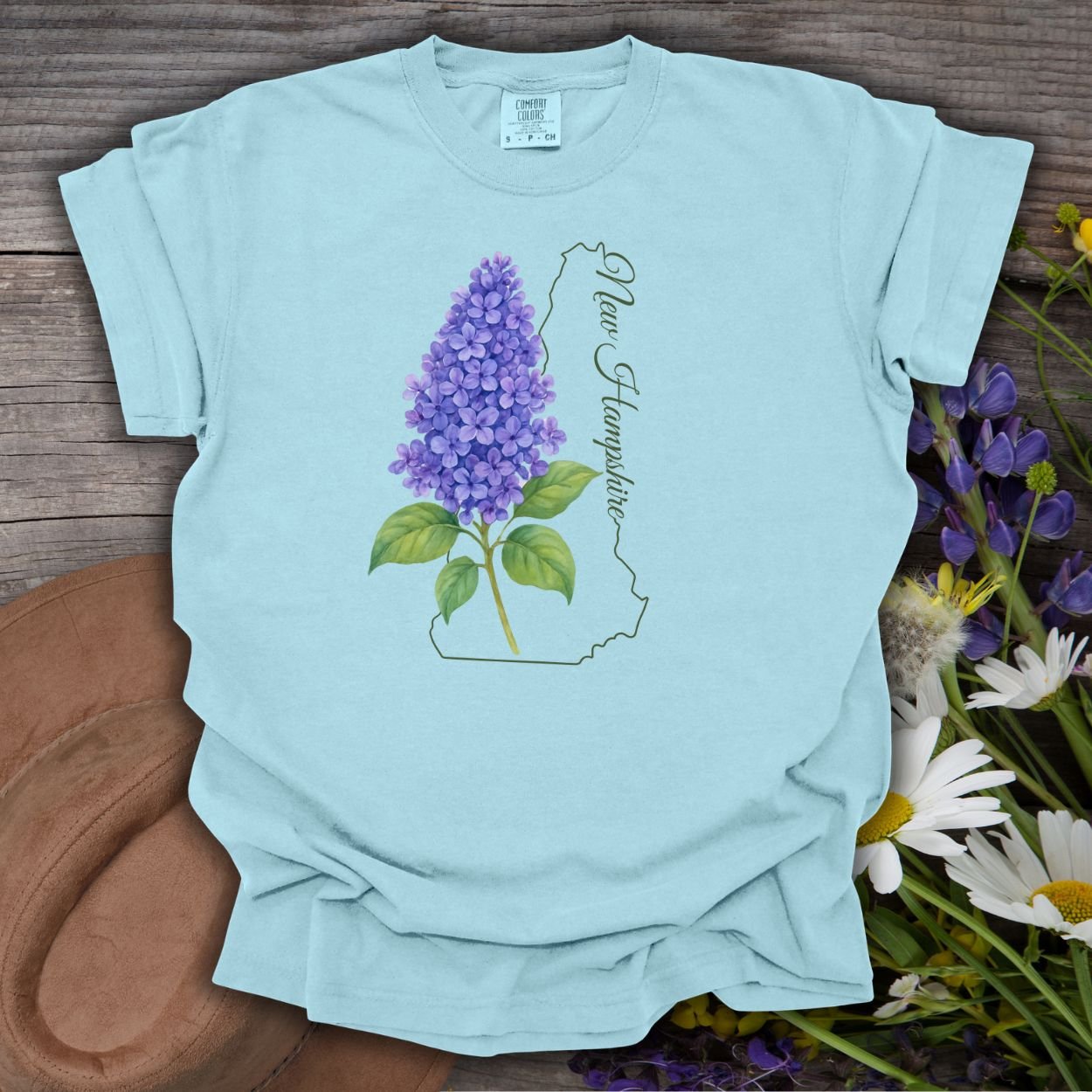 Chambray blue cotton t-shirt with a watercolor lilac sprig and New Hampshire state outline.