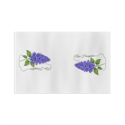 White microfiber tea towel with two purple lilac sprigs and "New Hampshire" text inside state outlines.