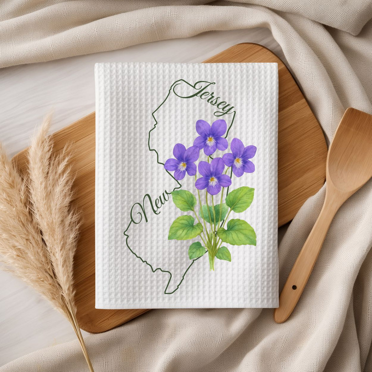 White microfiber tea towel with purple meadow violets and a green New Jersey state outline.