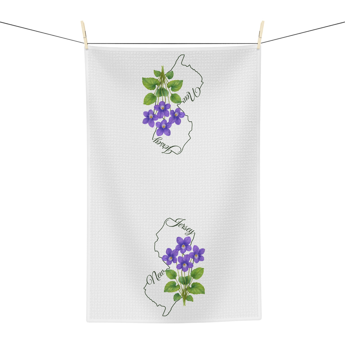 White microfiber tea towel with purple violet blooms and New Jersey outline, hanging on a clothesline.