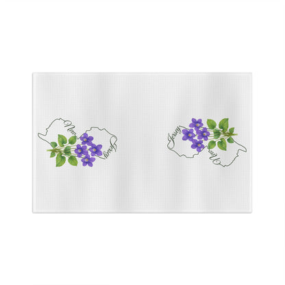 White microfiber tea towel with two New Jersey outlines, each adorned with purple violet blooms.