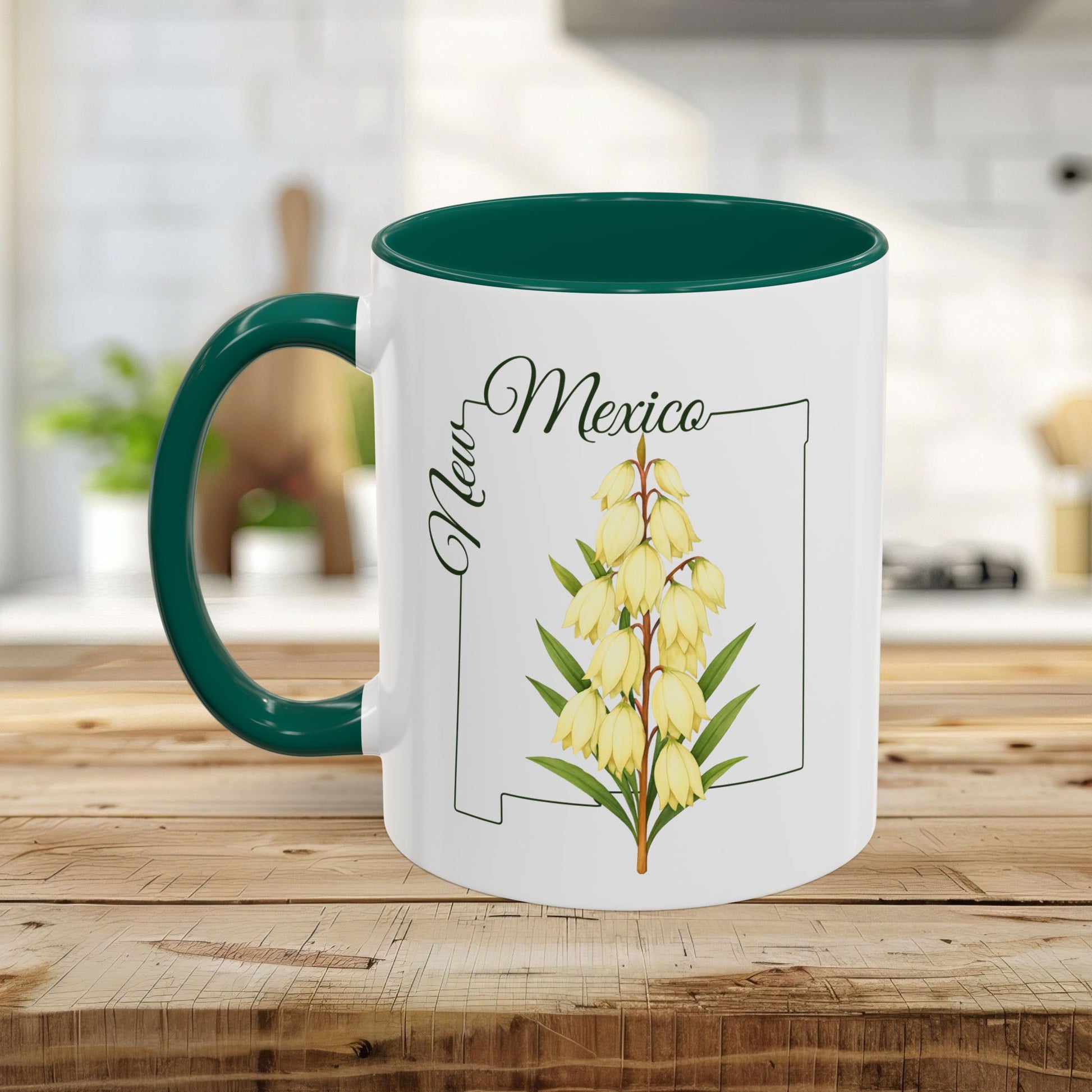 White ceramic mug with green handle and interior, featuring a Yucca flower and New Mexico outline.