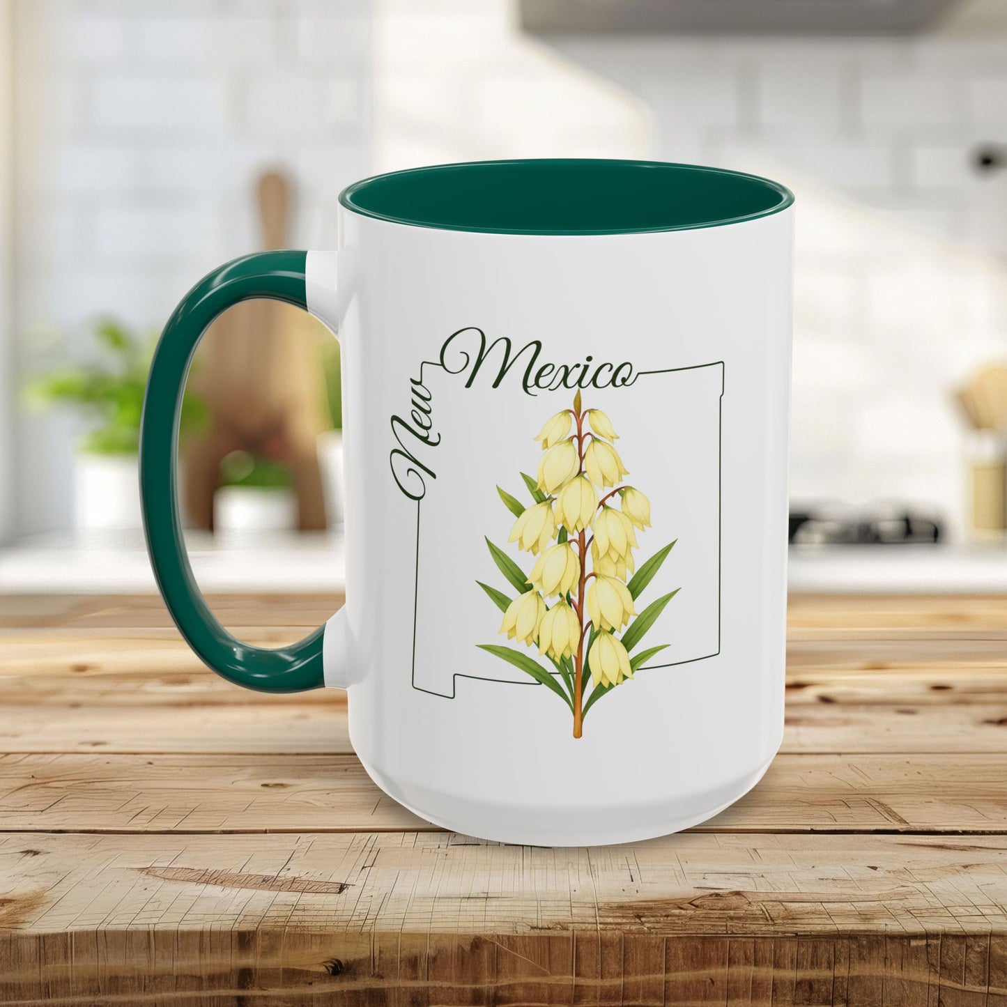 White ceramic mug with green handle and interior, featuring a New Mexico outline and Yucca flower illustration.