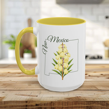 White ceramic mug with yellow interior and handle, featuring a New Mexico state outline and Yucca flower illustration.