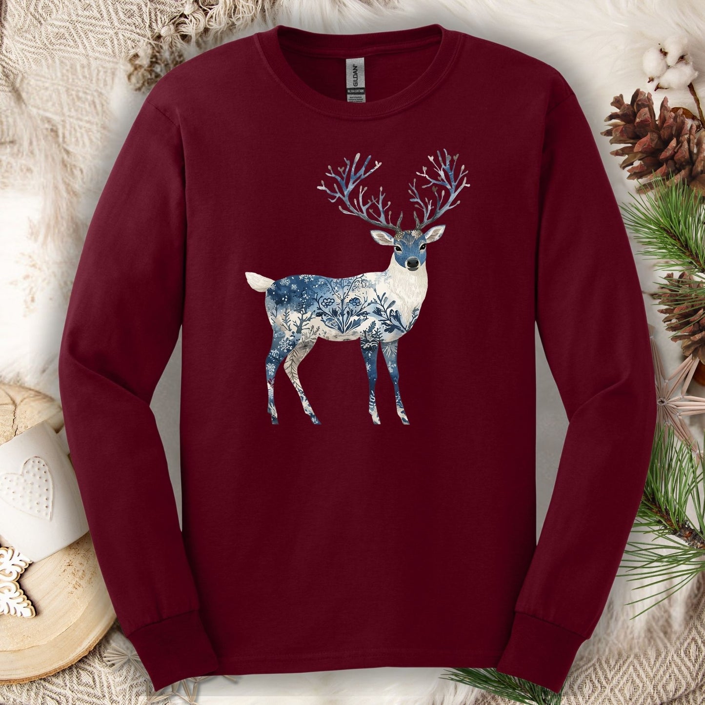 Maroon long-sleeve tee with a hand-painted stag silhouette featuring blue and white winter landscape texture.