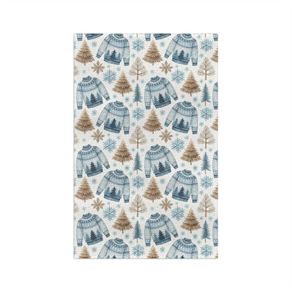 Nordic Fair Isle sweater microfiber tea towel with blue sweaters, pine trees, and snowflakes.