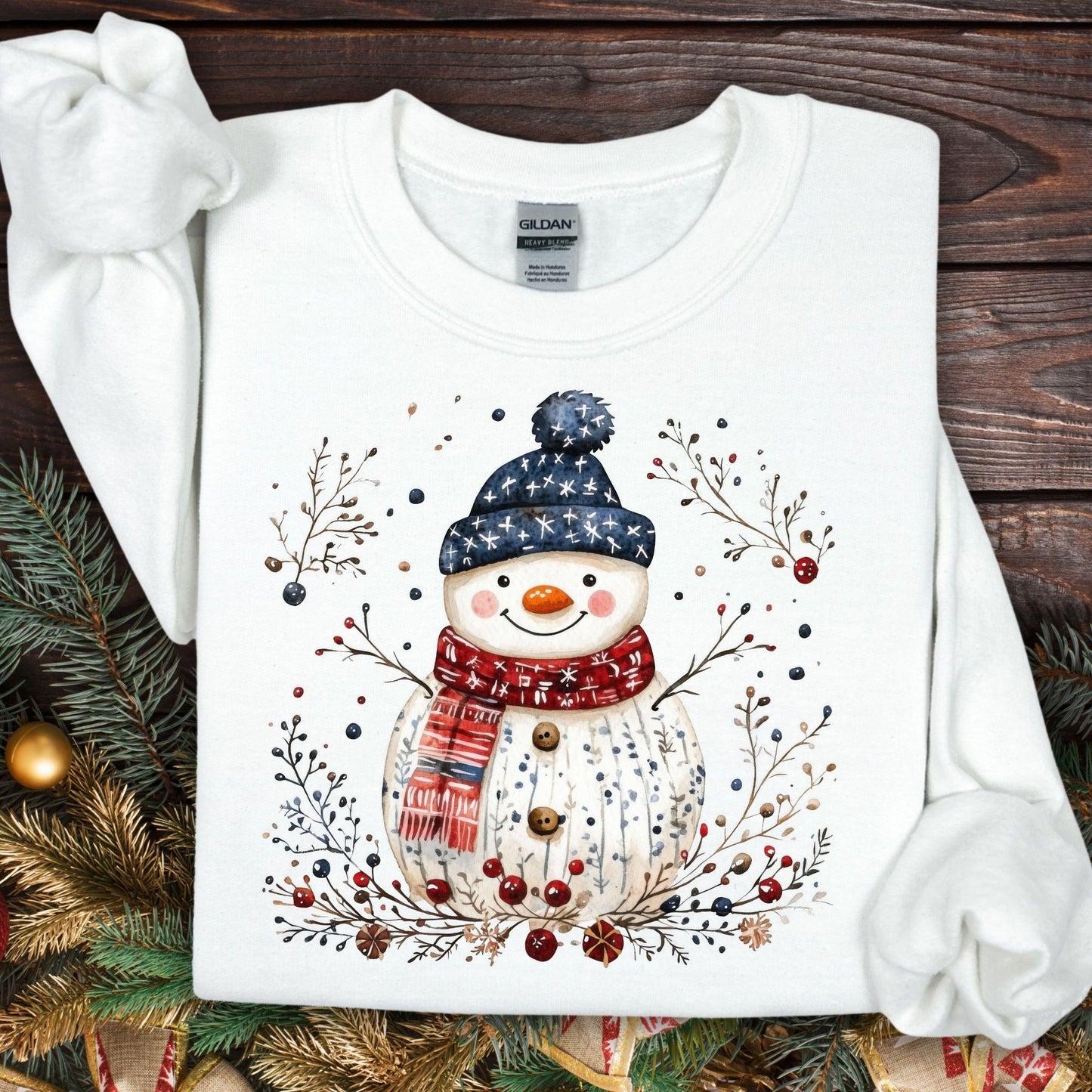 White Gildan fleece sweatshirt with a Nordic folk-art snowman, branches, and berries design.
