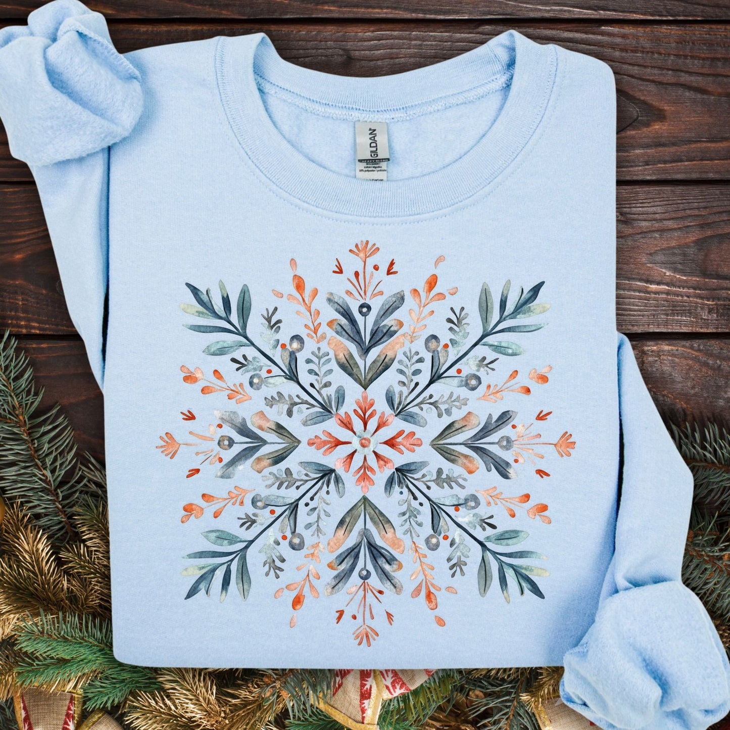 Light blue Gildan fleece sweatshirt with a watercolor Nordic snowflake design in red, blue, and green.