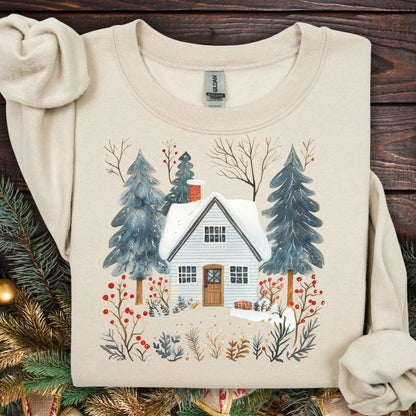 Sand crewneck sweatshirt with a snowy Nordic cabin and pine trees design.