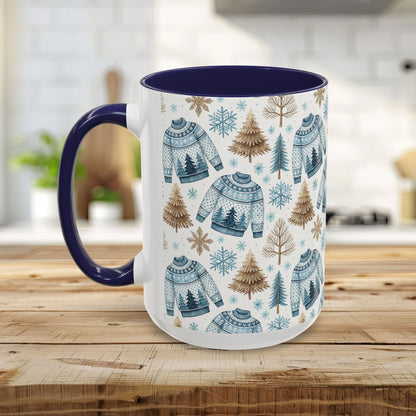 White ceramic mug with blue handle and interior, featuring a watercolor Nordic fair isle sweater and evergreen tree pattern.