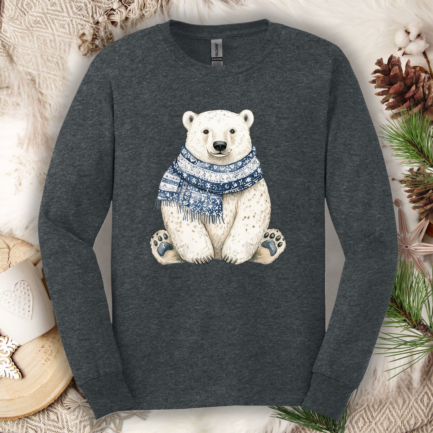 Dark Heather long-sleeve tee with a hand-painted polar bear wearing a blue knitted scarf, surrounded by winter decor.
