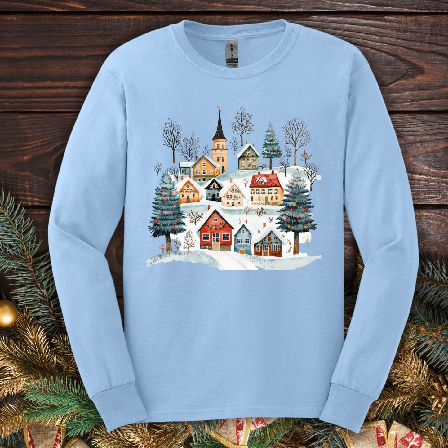 Light blue Gildan Softstyle long sleeve tee with a watercolor Nordic winter village design.