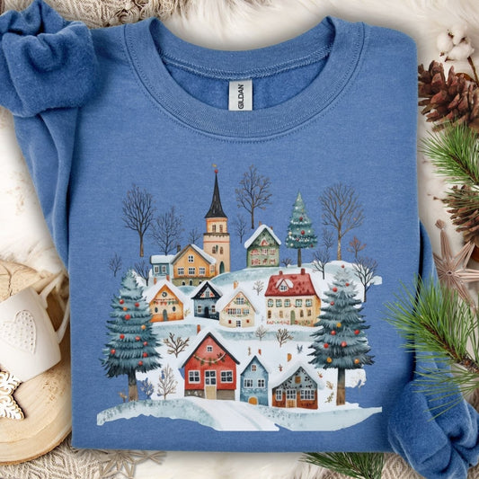 Indigo Blue Nordic Winter Village sweatshirt with folk-art design of snow-covered cottages and trees.