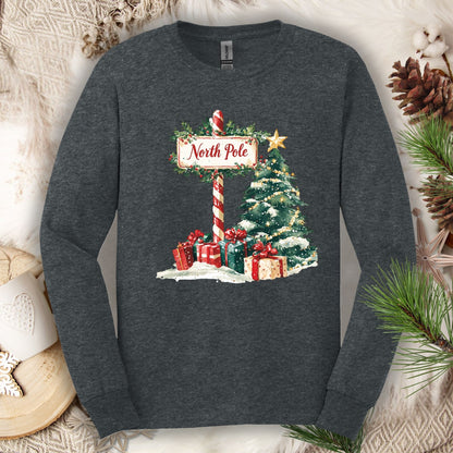 Dark Heather Gildan long sleeve tee with a watercolor North Pole sign, Christmas tree, and gifts.