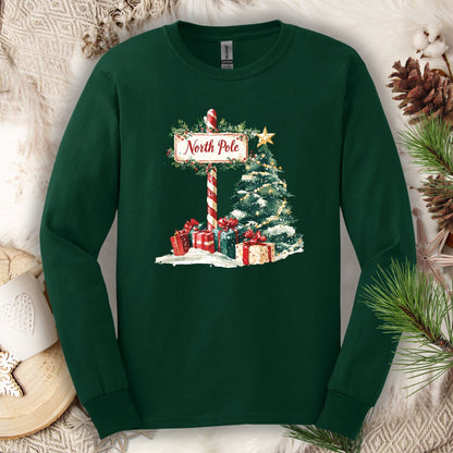 Forest Green Gildan long sleeve tee with a watercolor North Pole sign, Christmas tree, and gifts.