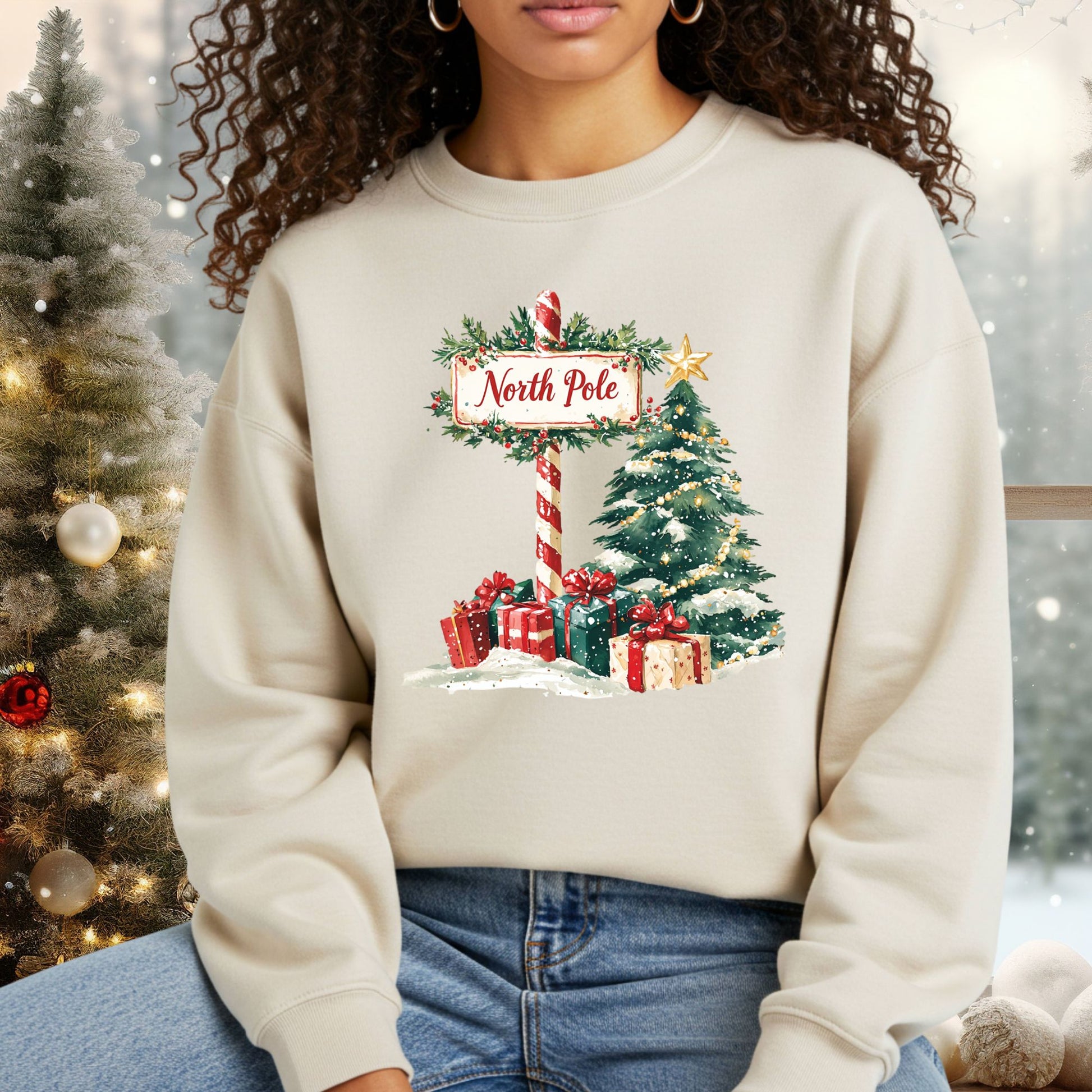 Beige Gildan 18000 sweatshirt with a watercolor North Pole sign, Christmas tree, and gifts.