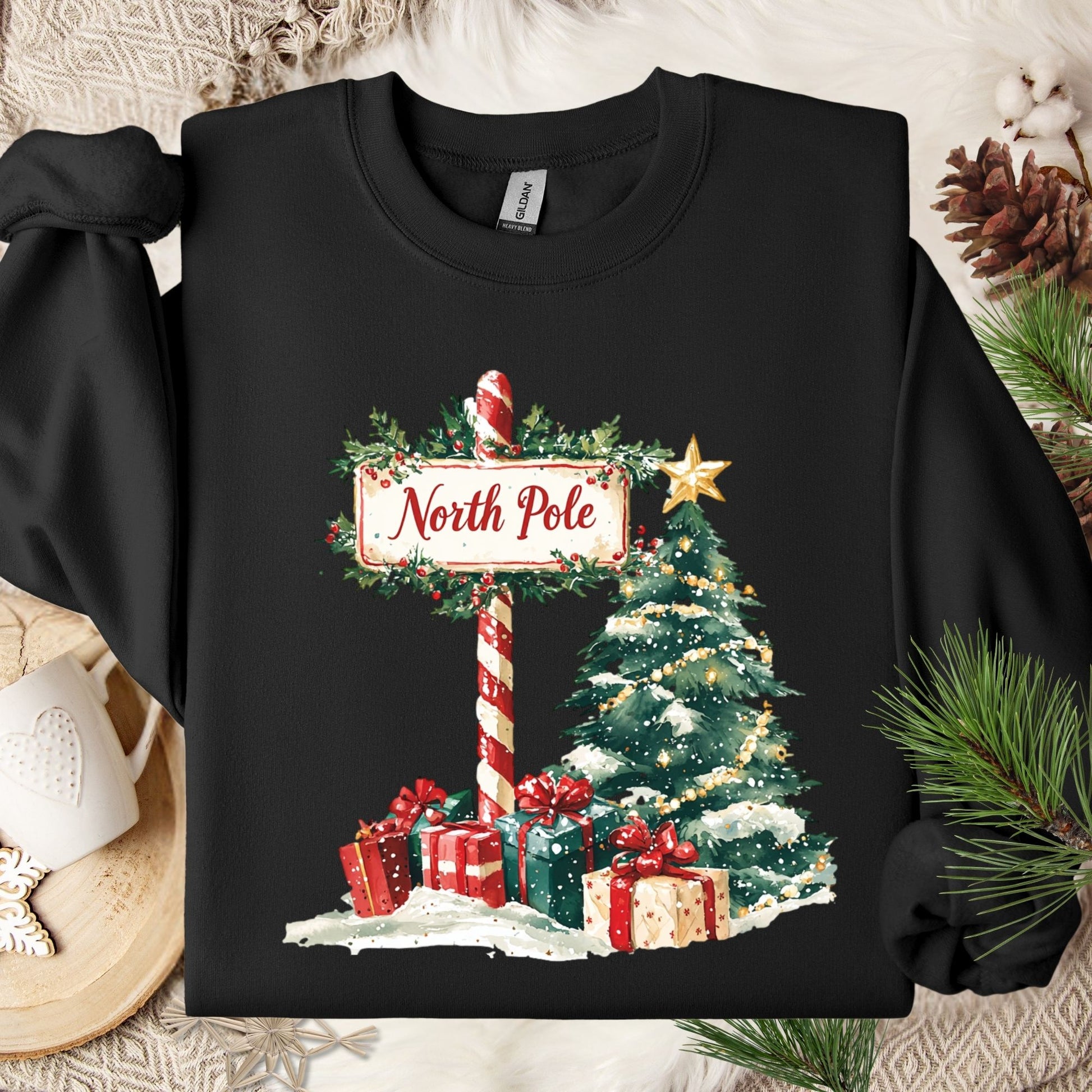 Black Gildan sweatshirt with a watercolor North Pole sign, Christmas tree, and gifts.