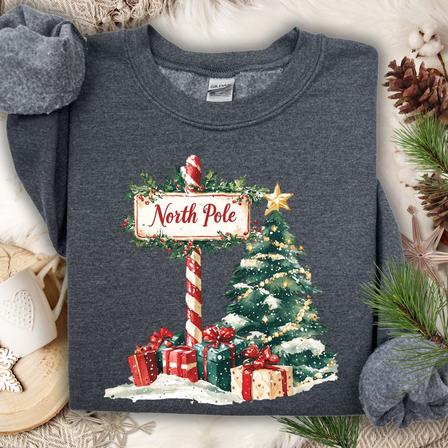 Dark Heather Gildan 18000 sweatshirt with a watercolor North Pole sign, Christmas tree, and gifts.