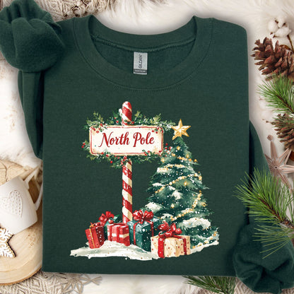 Forest Green North Pole Christmas sweatshirt with watercolor tree, gifts, and snowy sign.