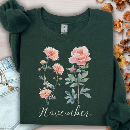 Forest Green unisex sweatshirt with watercolor chrysanthemum and peony flowers, "November" text, and ribbed collar.