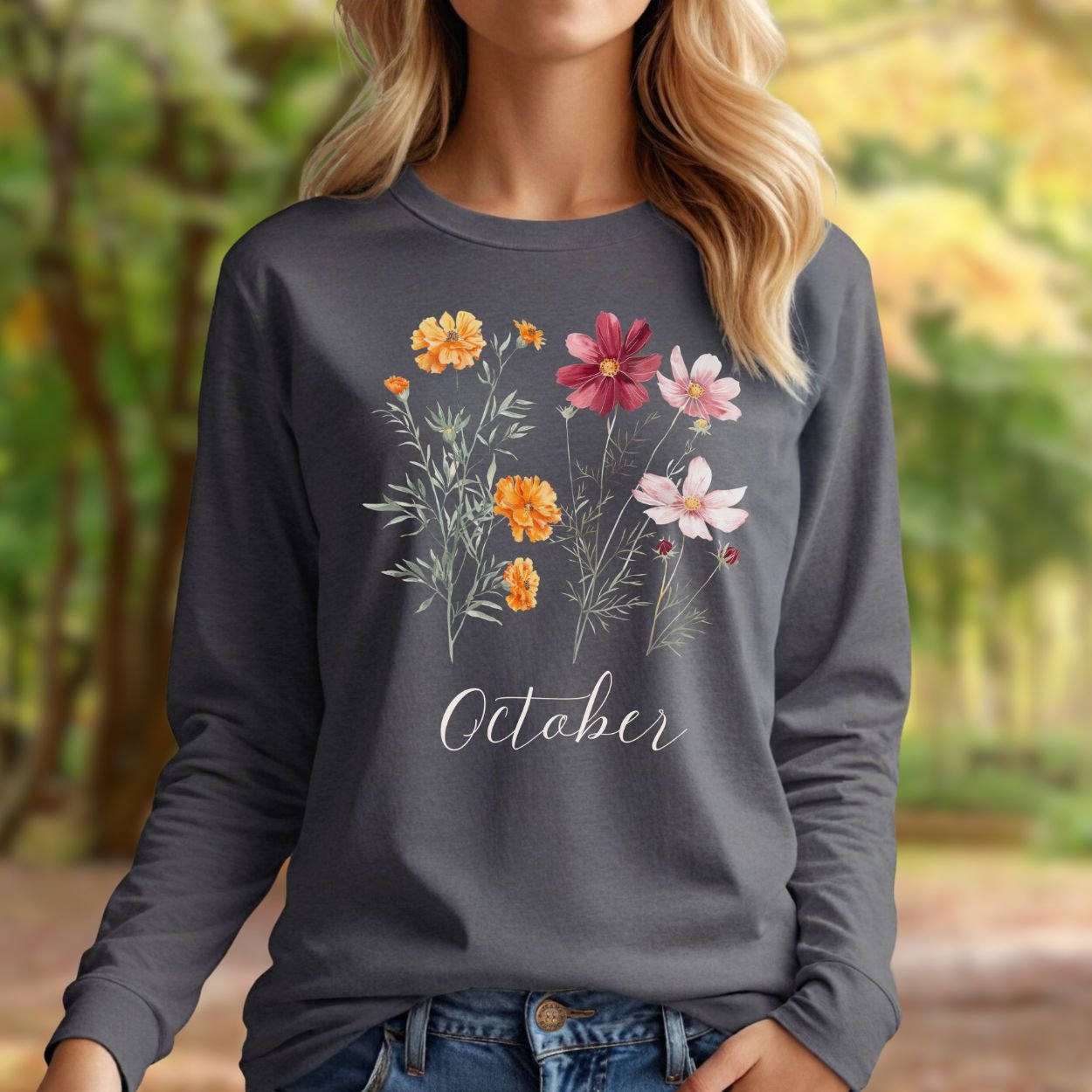 Charcoal long sleeve tee with watercolor marigold and cosmos flowers, "October" text, on a woman.