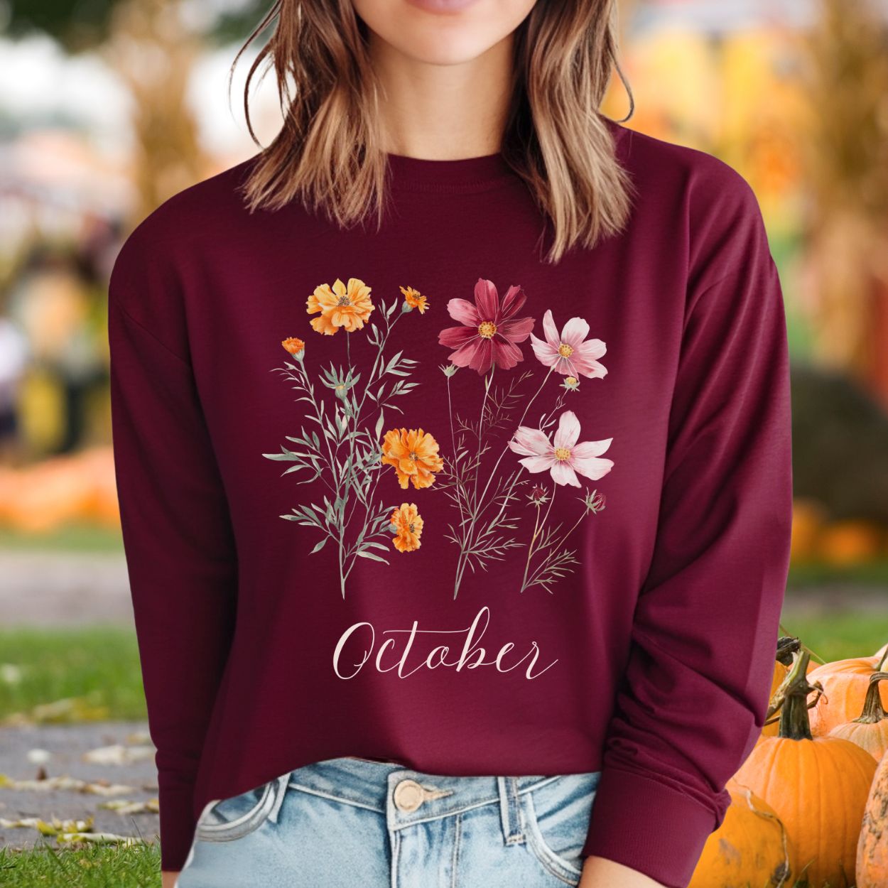 Maroon long sleeve tee with watercolor marigold and cosmos flowers, plus "October" script.