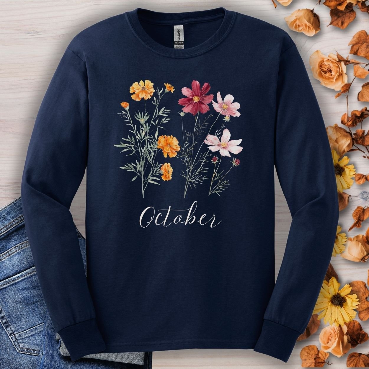 Navy long sleeve tee with watercolor marigold and cosmos flowers, "October" script, and vintage-feel cotton.