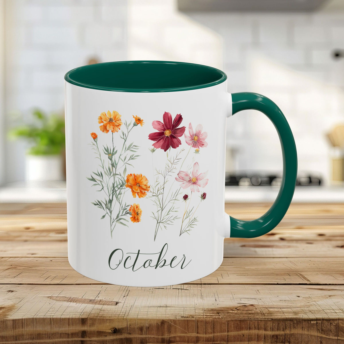 White ceramic 11oz mug with green handle and interior, featuring watercolor cosmos and marigold flowers, and "October" script.