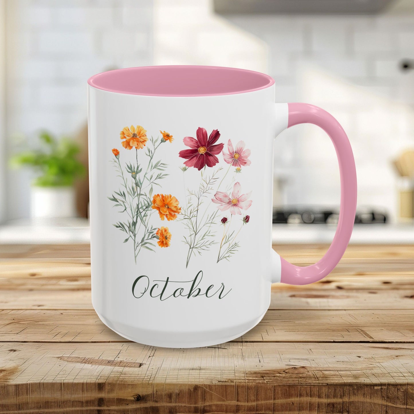 White 15oz ceramic mug with pink handle and interior, featuring watercolor cosmos and marigold flowers and "October" text.