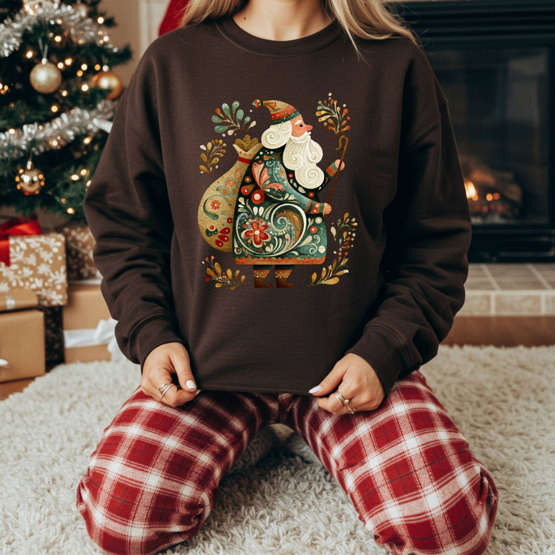 Brown Gildan sweatshirt with colorful folk art St. Nicholas design, worn by a person in plaid pajamas.